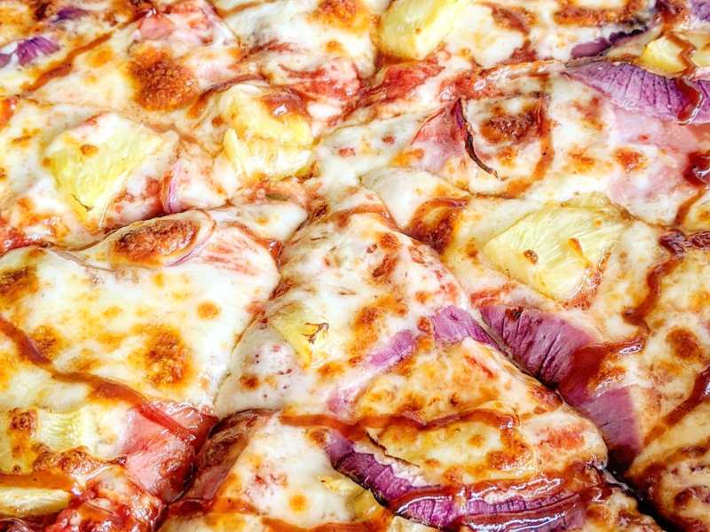 a pizza sitting on top of a pan covered in cheese