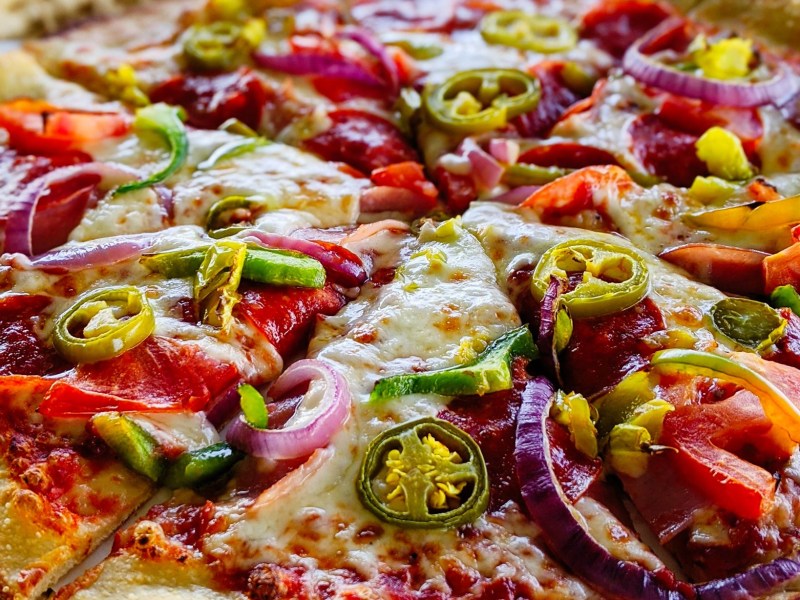 a pizza sitting on top of a wooden table
